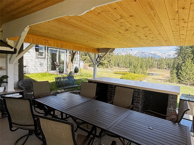 view of patio / terrace with a mountain view, outdoor dining space, and outdoor dry bar
