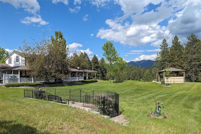 view of yard featuring a gazebo, fence, and a mountain view