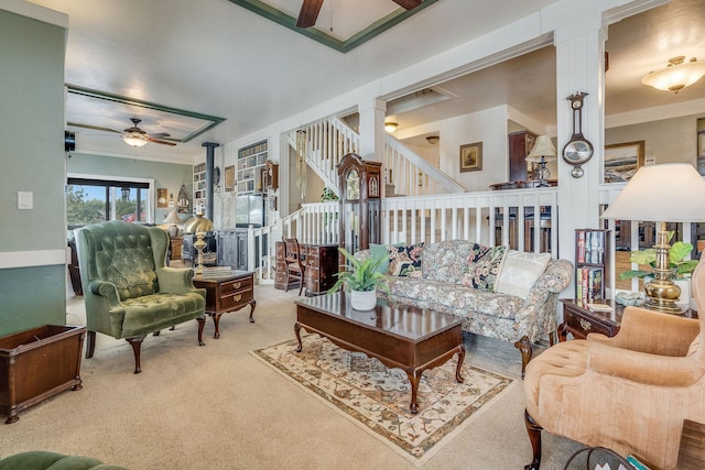 living room with stairway, carpet, crown molding, and ceiling fan