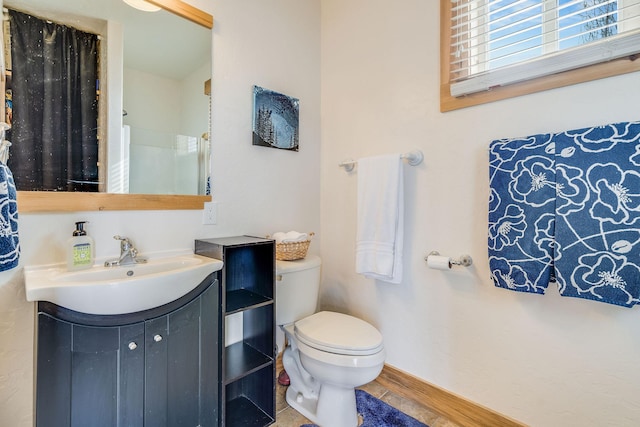 bathroom with baseboards, toilet, wood finished floors, and vanity