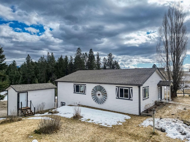 view of front of home featuring roof with shingles and an outbuilding