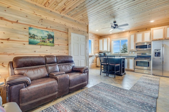 living area with a ceiling fan, stone finish flooring, recessed lighting, wood walls, and wood ceiling