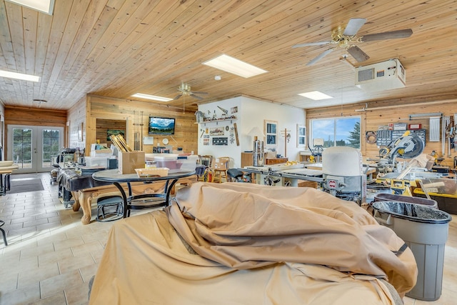 interior space featuring wooden walls, wood ceiling, and ceiling fan