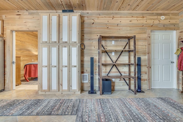 interior space with stone tile floors, wood walls, and wooden ceiling