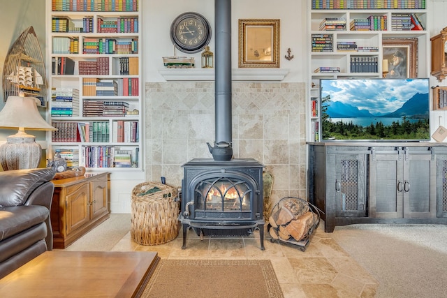 carpeted living area with tile walls and a wood stove