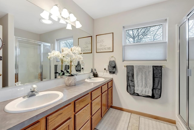 bathroom with a sink, a shower stall, baseboards, and double vanity