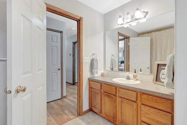 bathroom featuring ensuite bathroom, wood finished floors, and vanity