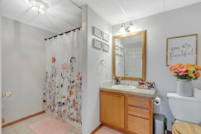 bathroom with toilet, a shower with shower curtain, vanity, tile patterned flooring, and baseboards