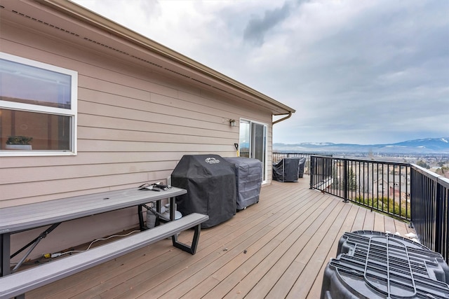 wooden deck with a grill and a mountain view