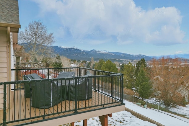 snow covered back of property featuring a mountain view