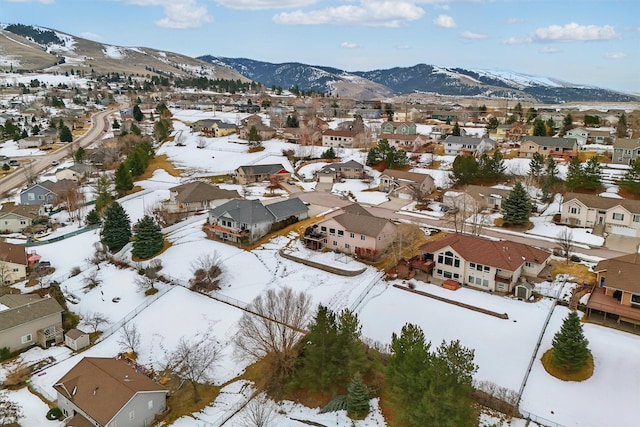 snowy aerial view featuring a residential view and a mountain view