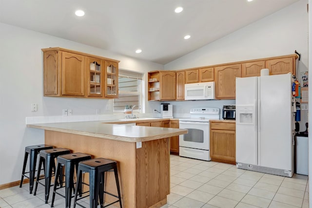 kitchen with a peninsula, white appliances, a sink, light countertops, and glass insert cabinets