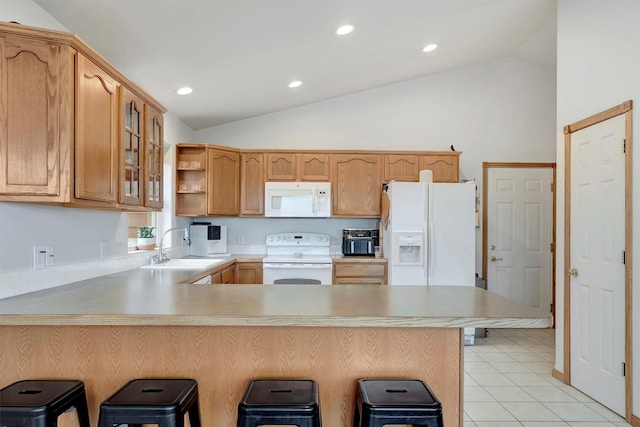 kitchen with light tile patterned floors, glass insert cabinets, a sink, white appliances, and a peninsula