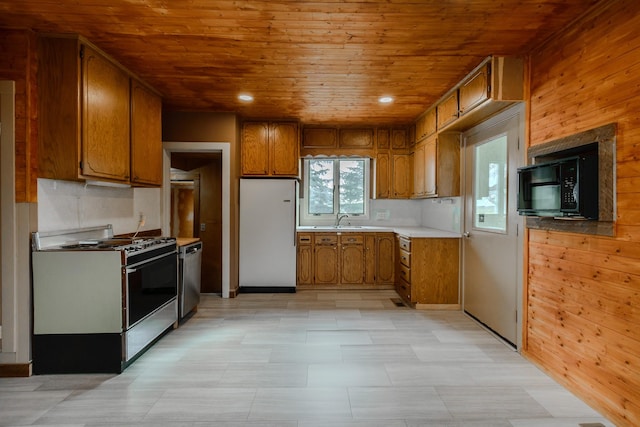 13195 US Highway 91 N, Conrad, MT 59425 - kitchen featuring range with gas cooktop, freestanding refrigerator, black microwave, brown cabinets, and wood ceiling