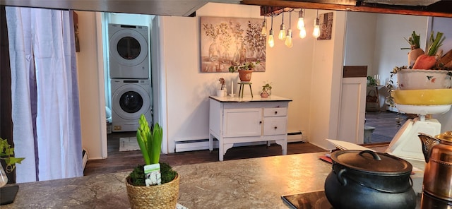 interior space featuring laundry area, a baseboard heating unit, stacked washer / dryer, and wood finished floors