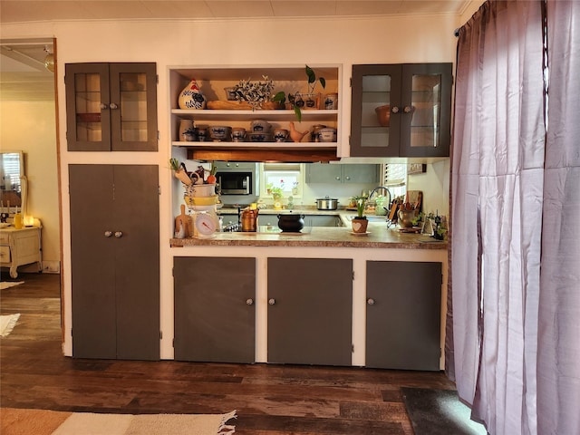 bar with dark wood-style flooring, stainless steel microwave, and a sink