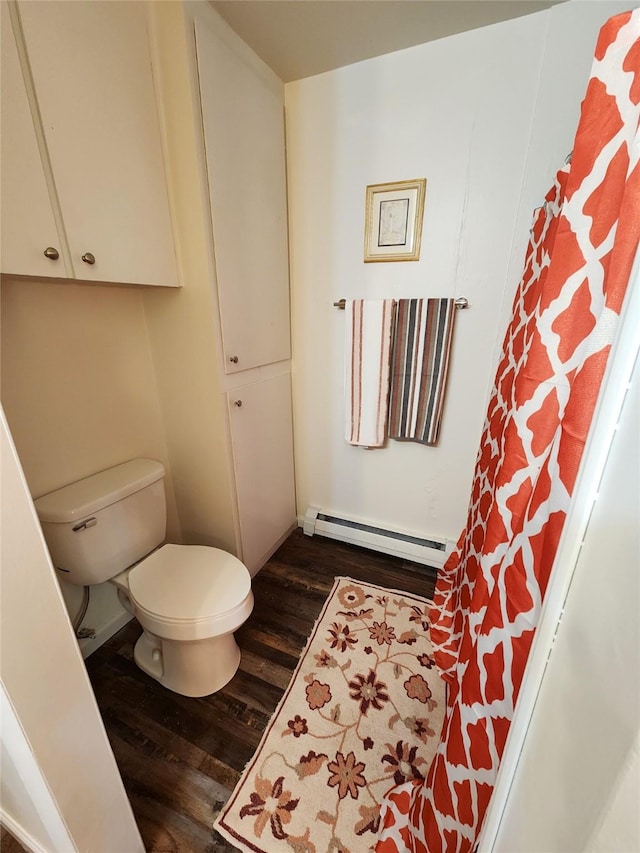 bathroom featuring toilet, baseboard heating, and wood finished floors