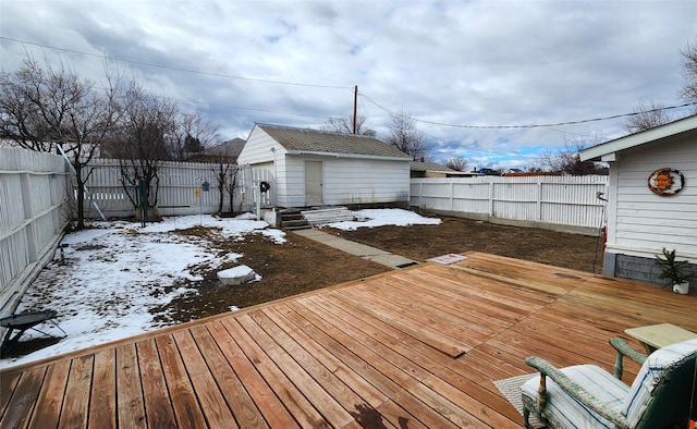 snow covered deck featuring a fenced backyard and an outbuilding