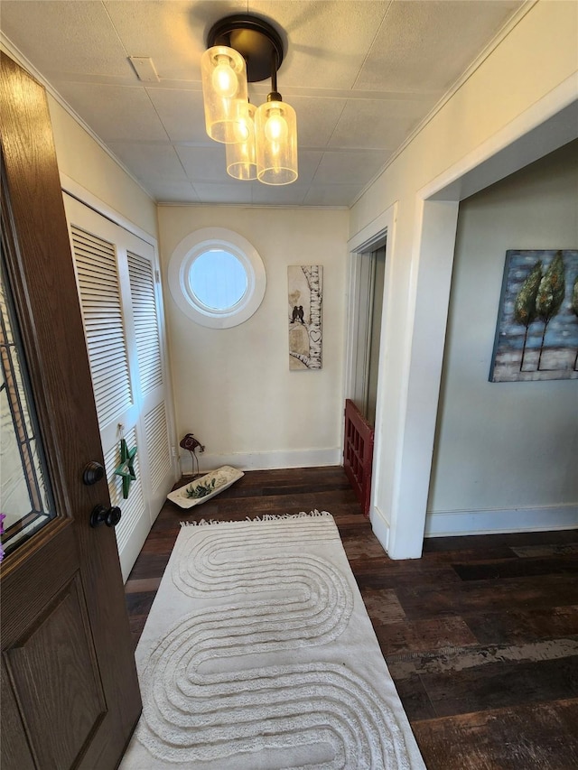 interior space featuring a chandelier, a closet, baseboards, and wood finished floors