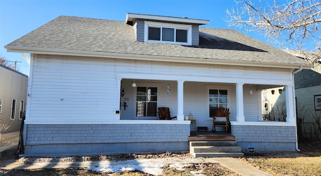 bungalow-style home with a porch and roof with shingles