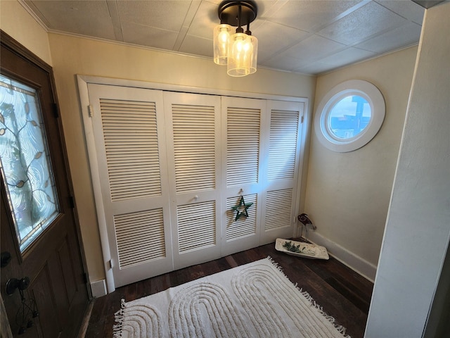 foyer featuring baseboards and wood finished floors