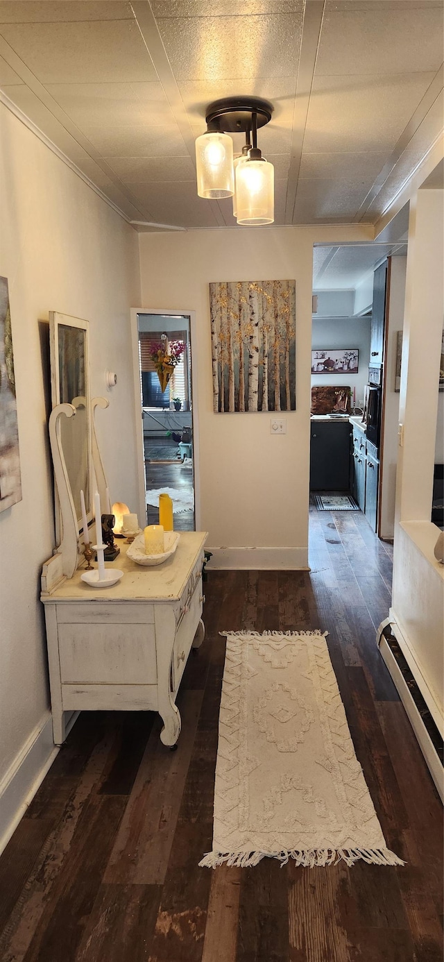 corridor with dark wood-style flooring and baseboards