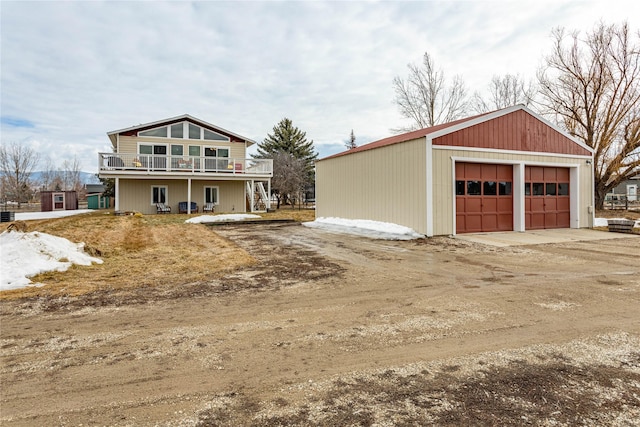 view of front of house with a garage and an outbuilding