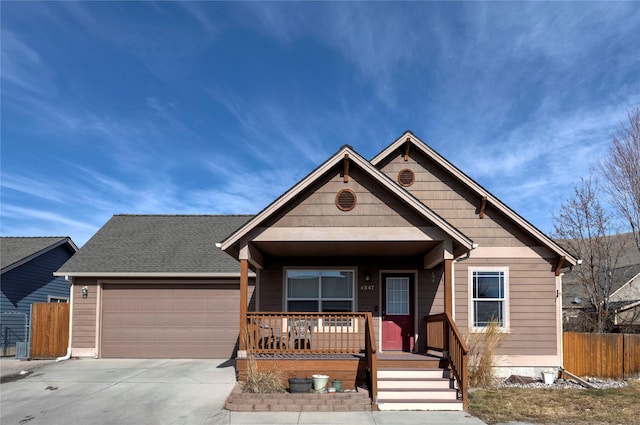 view of front of home with roof with shingles, a porch, concrete driveway, fence, and a garage