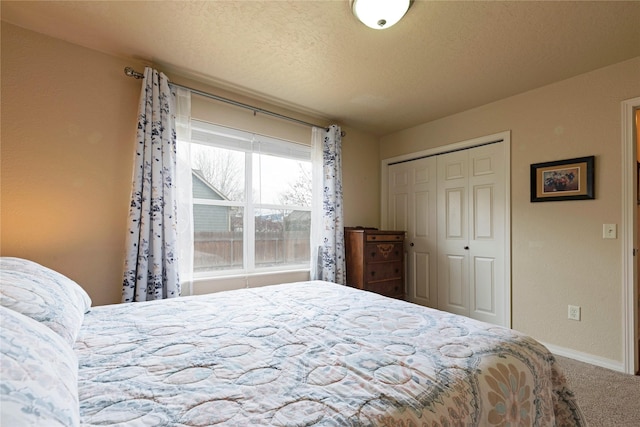 bedroom featuring a closet, carpet flooring, a textured ceiling, and baseboards