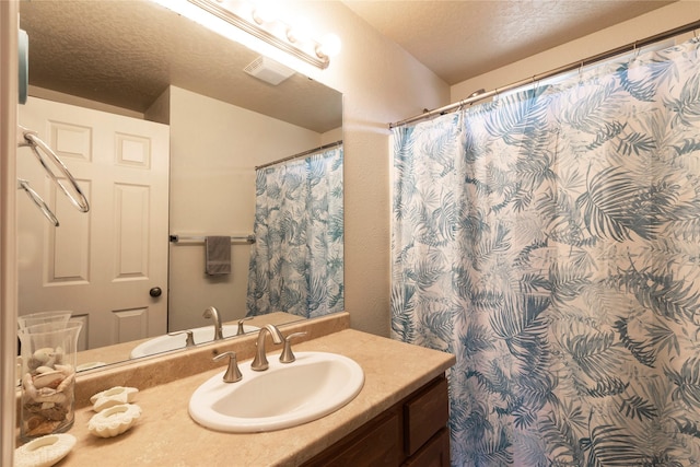 full bath with a shower with shower curtain, visible vents, a textured ceiling, and vanity