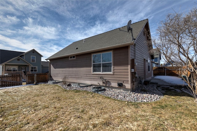 back of property with a yard, a patio, fence, and roof with shingles