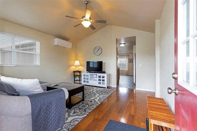 living area with a wall mounted air conditioner, lofted ceiling, a ceiling fan, wood finished floors, and baseboards