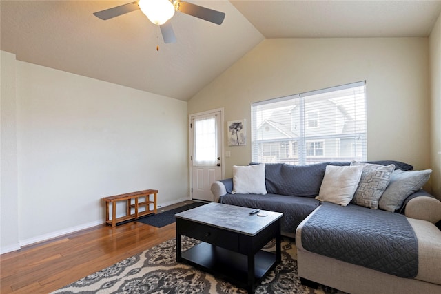 living room with lofted ceiling, ceiling fan, wood finished floors, and baseboards