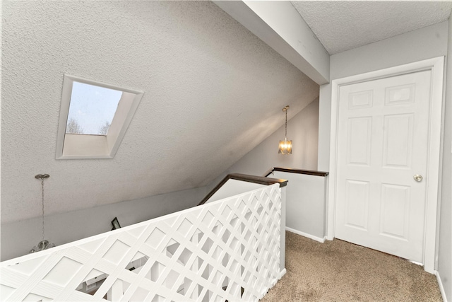 carpeted bedroom featuring a chandelier, lofted ceiling, a textured ceiling, and baseboards