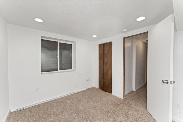 unfurnished bedroom featuring carpet, recessed lighting, a closet, a textured ceiling, and baseboards