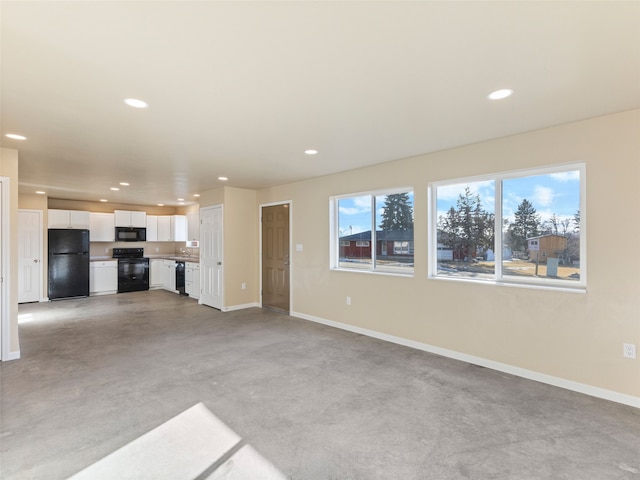 unfurnished living room with finished concrete floors, recessed lighting, and baseboards