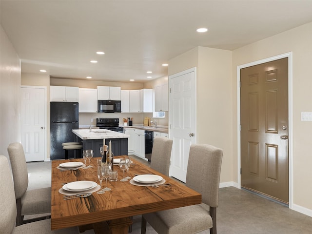 dining room featuring finished concrete floors, baseboards, and recessed lighting