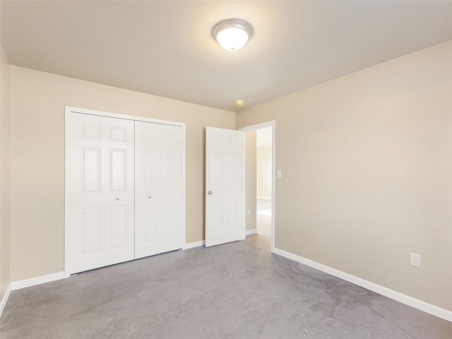 unfurnished bedroom featuring concrete flooring, a closet, and baseboards