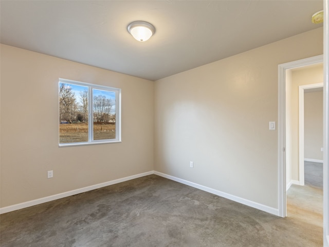 unfurnished room with baseboards