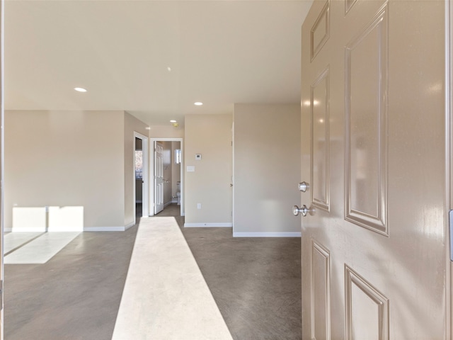 interior space featuring baseboards, recessed lighting, and finished concrete floors