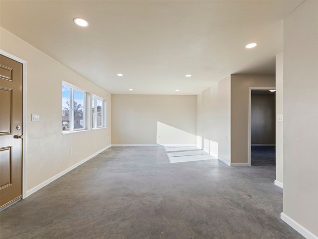 unfurnished room featuring concrete floors, baseboards, and recessed lighting