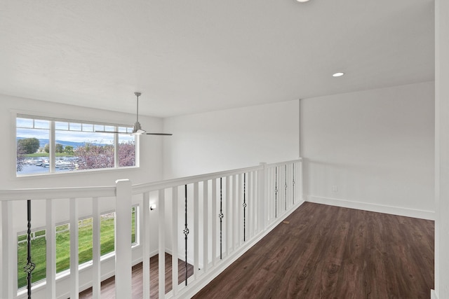 corridor featuring baseboards, dark wood finished floors, and recessed lighting