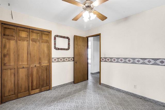 unfurnished bedroom with light carpet, a closet, a ceiling fan, and baseboards