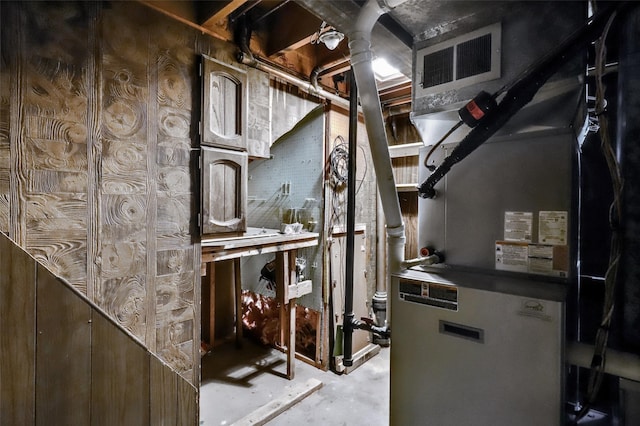 utility room with heating unit and visible vents