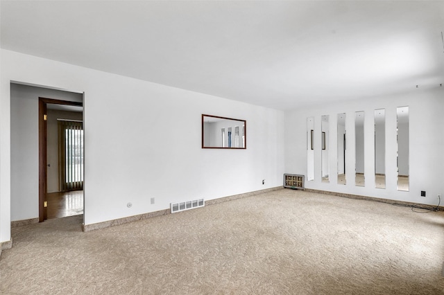 carpeted empty room with visible vents and baseboards