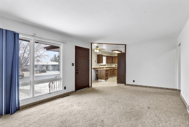 interior space featuring light carpet and baseboards