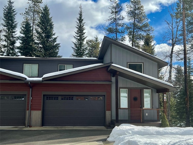 view of front of home featuring aphalt driveway, an attached garage, and board and batten siding