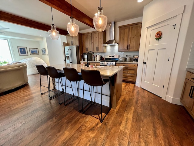 kitchen featuring stainless steel appliances, open floor plan, wall chimney range hood, dark wood-style floors, and tasteful backsplash