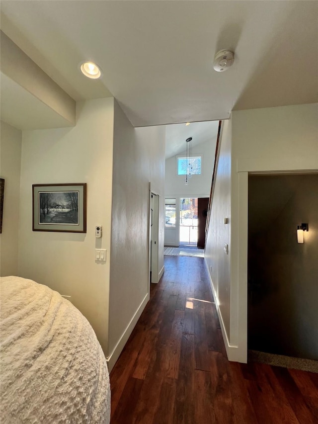 hallway with vaulted ceiling, dark wood-style flooring, recessed lighting, and baseboards