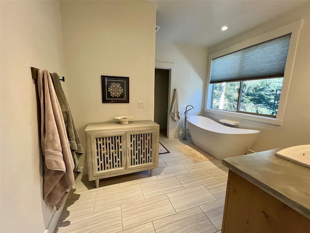 bathroom featuring a soaking tub and vanity